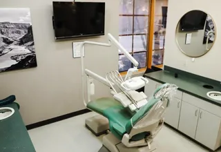 Modern dental treatment room with chair, overhead monitor, and clinical equipment at Valley Dental Care.